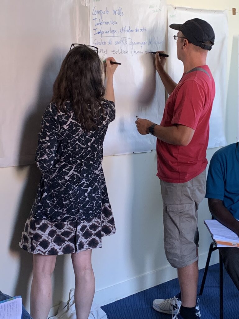 Participants rédigeant en trois langues une synthèse collective sur un panneau